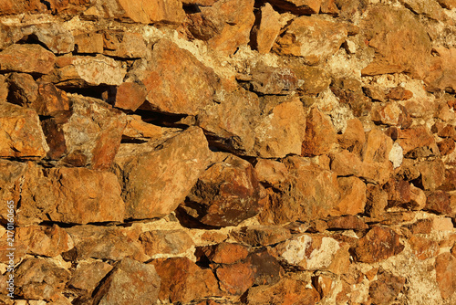 Foto Close-up shot of old rustic stone wall texture illuminated by warm golden sunlig