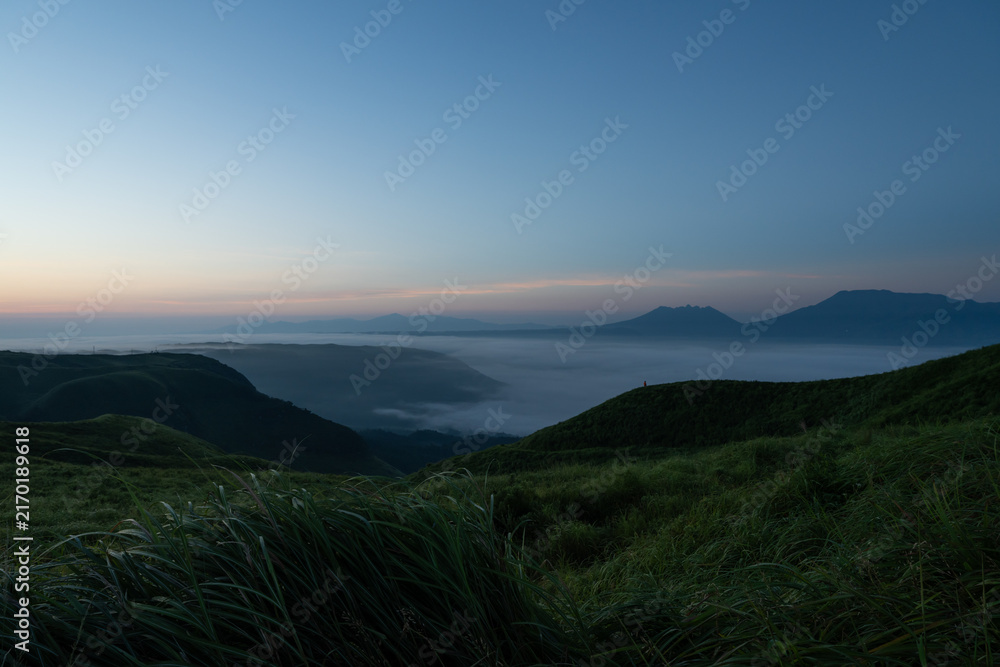 Fototapeta premium 夜明けの大観峰から眺める北外輪山の草原と阿蘇谷の雲海