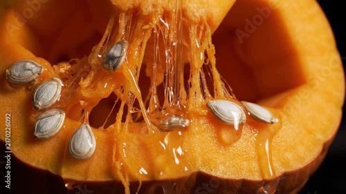 Cinematic 4K Seamless Loop Close-up of Viscous Liquid Dripping Over Pumpkin Guts and Seeds with Moody Lighting
