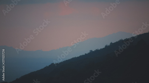 Foto A scenic landscape view of layered mountain ridges fading into a soft, hazy twilight or early morning sky, creating a peaceful atmospheric depth