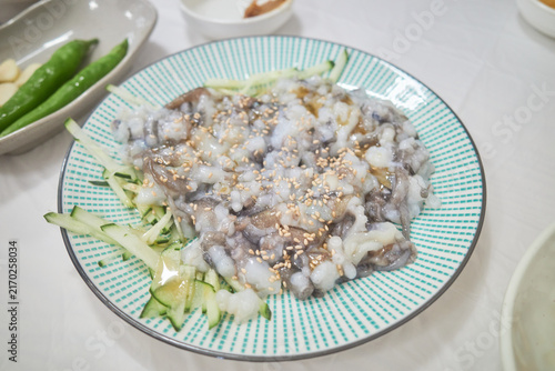 Photography Fresh chopped small octopus delicacy garnished with cucumber and sesame seeds on a plate