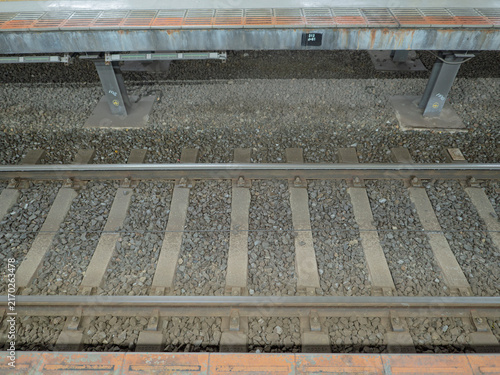 Obraz w ramie 駅のプラットホームから見下ろす線路と敷き詰められたバラスト軌道
