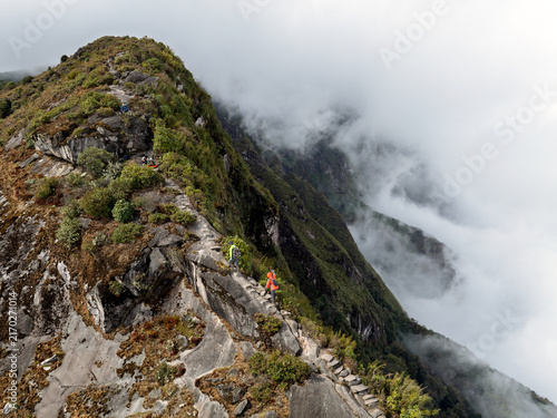 Hiker on a fog-covered rocky mountain ridge in Vietnam