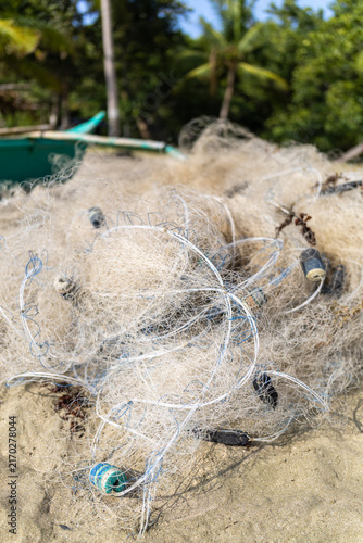фотографія Tangled fishing net with floats on a tropical sandy beach