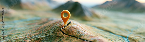 A close-up of a topographic map with a red location pin marking a specific mountainous area.