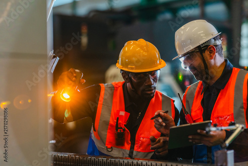 Technicians inspecting auto parts at liquid-filled station in auto parts factory