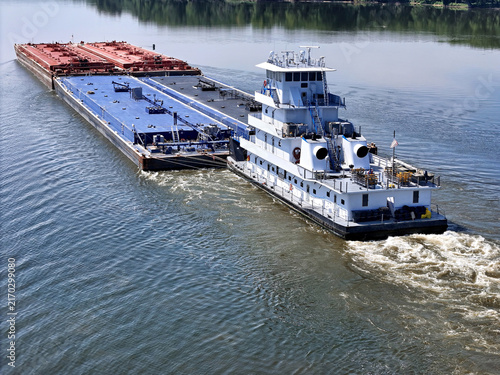 Obraz na płótnie tugboat navigating South down the Mississippi river pushing a set of liquid carg