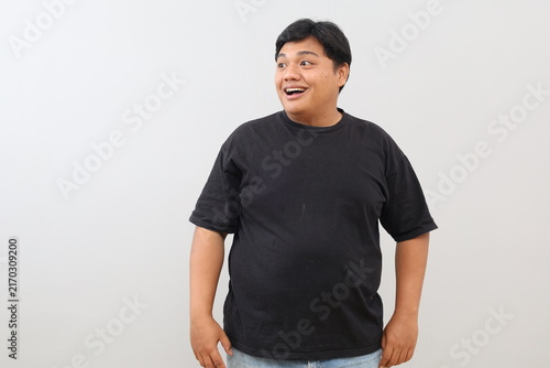 Foto A heavy-set man appears surprised, amazed, cheerful, happy, and satisfied, turning his head to the side against a white background