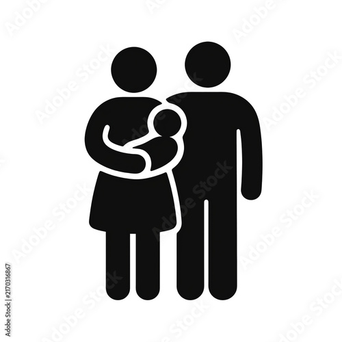 two parents standing together with a baby between them
