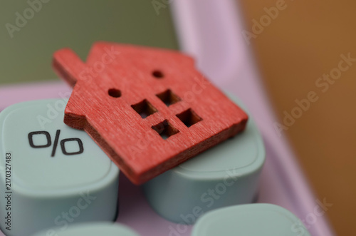Mortgage Rate Concept with Wooden House on Calculator Percent Key