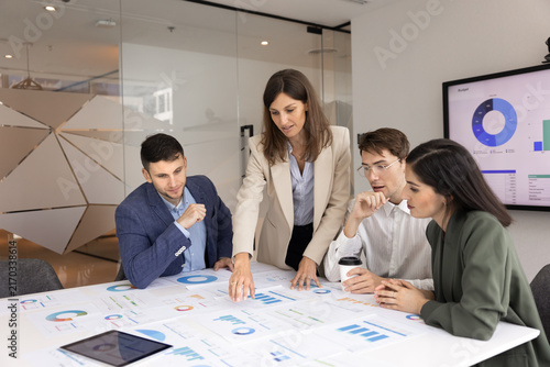 Photography Female business leader presenting company analytics to diverse consulting team e