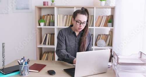 Business routine. Professional atmosphere. Busy woman manager at office desk with laptop working with documents at modern workspace.