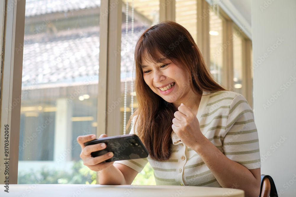 Obraz premium Woman Playing Game on Smartphone at Home, Casual Mobile Gaming and Digital Lifestyle