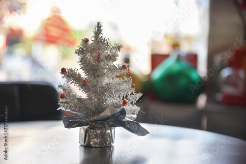 Close-up view of Christmas gifts under a decorated tree with red wrapping in a cozy home interior.