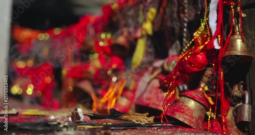 Mustang, Annapurna Circuit, Muktinath, Nepal, static shot of burning incense sticks, ritual fire, and ceremonial brass bells and red clothes