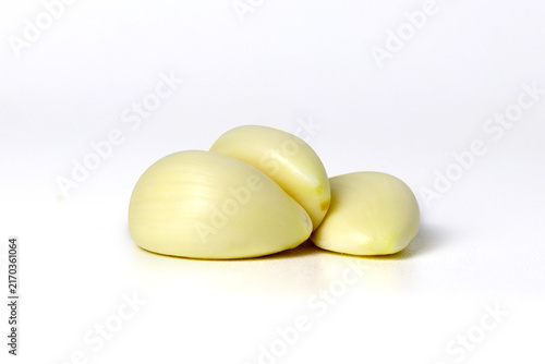 Fresh peeled garlic cloves arranged on a white surface