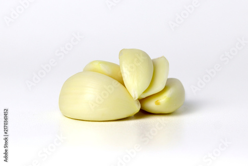 Fresh peeled garlic cloves arranged on a white surface