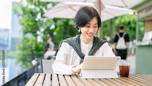 Foto Beautiful smiling adult business asian woman relax at outdoor terrace of cafe wi