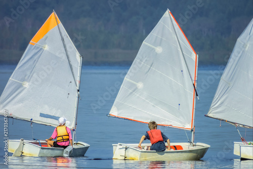 Training of young yachtsmen on the river on a summer day
