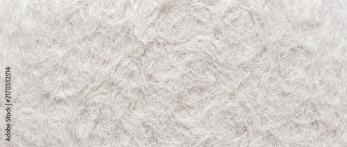 Soft white shaggy synthetic fur texture, cozy abstract background for winter textiles and comfortable home decor.