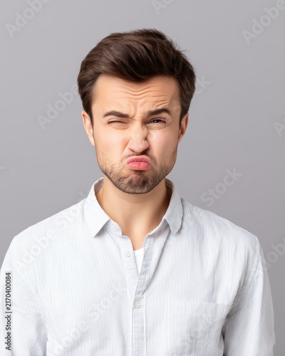Young man making a funny awkward and embarrassed facial expression
