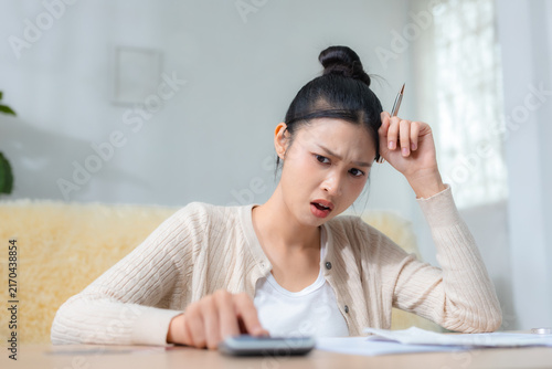 Bild auf Leinwand Worried women calculating household expenses and bills at home, struggling to manage her budget and money, finance, budget, bills, debt, expenses