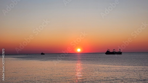 Canvastavla East Sea Sunrise Calm: A peaceful sunrise over the calm horizon of the East Sea, where morning sunlight spreads a reddish glow across the water to bring quiet serenity