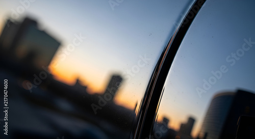 Modern Cityscape Sunset View Reflected in a Polished Vehicle Surface