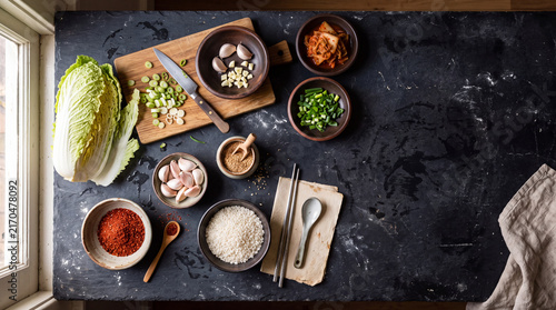 Overhead korean cooking ingredients layout with napa cabbage garlic rice and spices for recipe background and food blog design