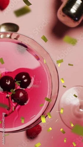 Animation of confetti falling and cocktail on pink background