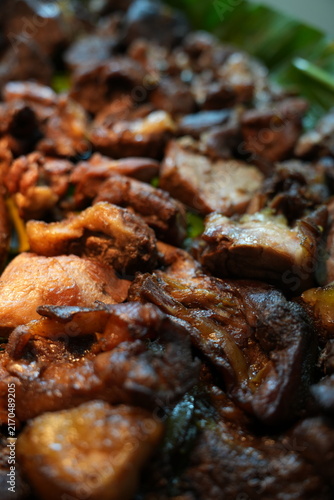 фотографія Close-up of braised meat and offal on banana leaves, showcasing traditional Asian street food cuisine