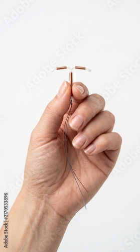 Female hand holding an IUD for contraceptive purpose  