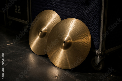 Polished orchestral cymbals leaning against padded cart backstage, music equipment and performance preparation concept