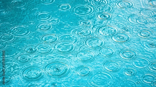 Blue raindrops creating ripples on water surface, turquoise background texture, water circles and drops pattern, nature rainfall scene, liquid waves and reflections, weather concept
