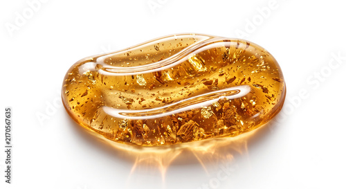 Macro shot of golden amber resin oil swatch with gold flakes and cedarwood texture