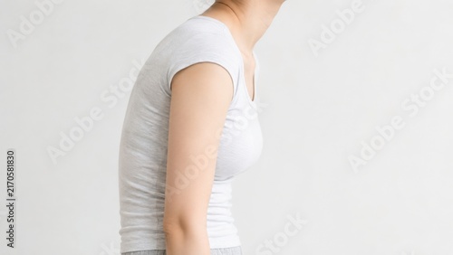Fototapeta 猫背で前かがみになった女性の横向き姿勢・姿勢改善イメージ