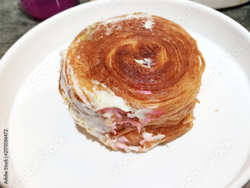 New york roll pastry on white plate with creamy icing and sweet filling, modern dessert trend