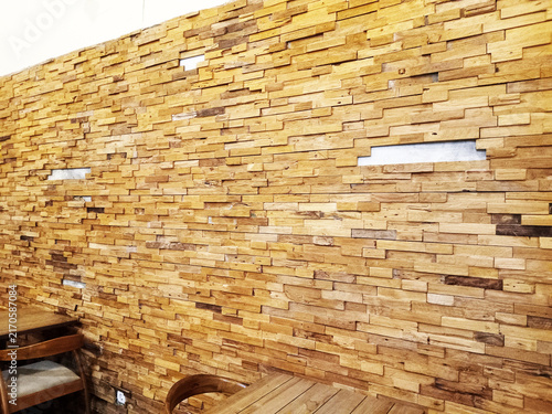 Wooden wall paneling with textural pattern and warm tones creating a rustic interior atmosphere
