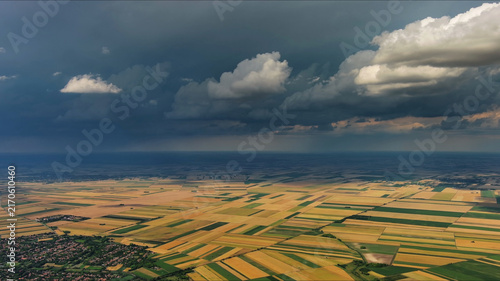 Agricultural fields under dramatic dark storm clouds