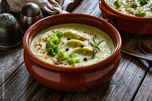 Cream of broccoli soup on wooden table

