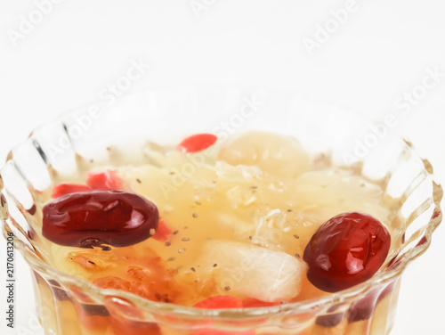 A close-up studio shot of a traditional Asian sweet dessert soup served in a clear glass bowl against a clean white background, with ample copy space at the top.