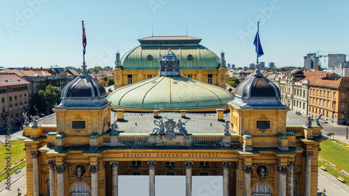 Aerial view of the Croatian National Theatre with its distinctive yellow facade and green dome, surrounded by urban architecture in Zagreb, Grad Zagreb, Croatia.