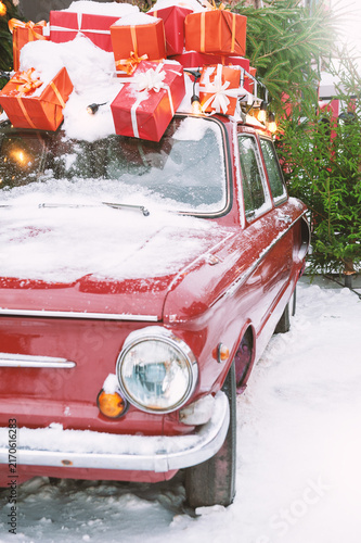 Vintage car with snowy decoration carries festive gifts