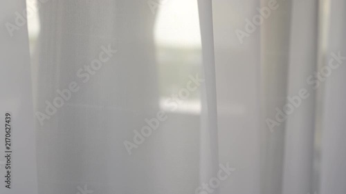 Sheer white curtains parting under soft daylight with gentle billow and layered vertical panels, with curtain, sheer, fabric, white detail, showing panel, gap,drape, fold context