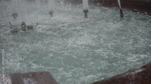 Fountain jets striking shallow pool creating frothy surface splashes and suspended droplets, with water, fountain, splash, spray detail, showing droplet, foam, ripple,turbulence context