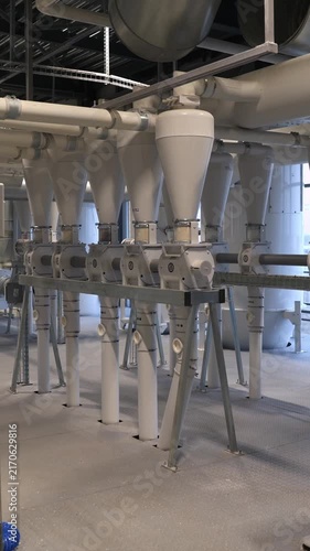 Vertical video. Pipelines and automated equipment machinery and conveyor system working inside a large at a contemporary industrial milling