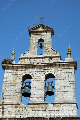 Church bell tower with a stork's nest under a blue sky. Spain - Burgos