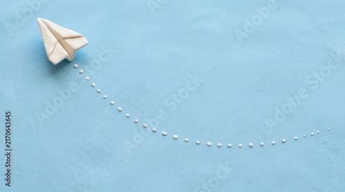 White paper plane on blue background.