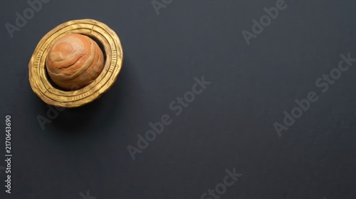 Saturn planet model on dark stone.