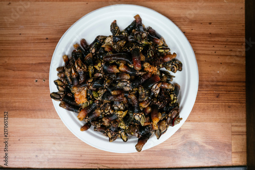 Plateful of fresh gooseneck barnacles percebes on wooden table